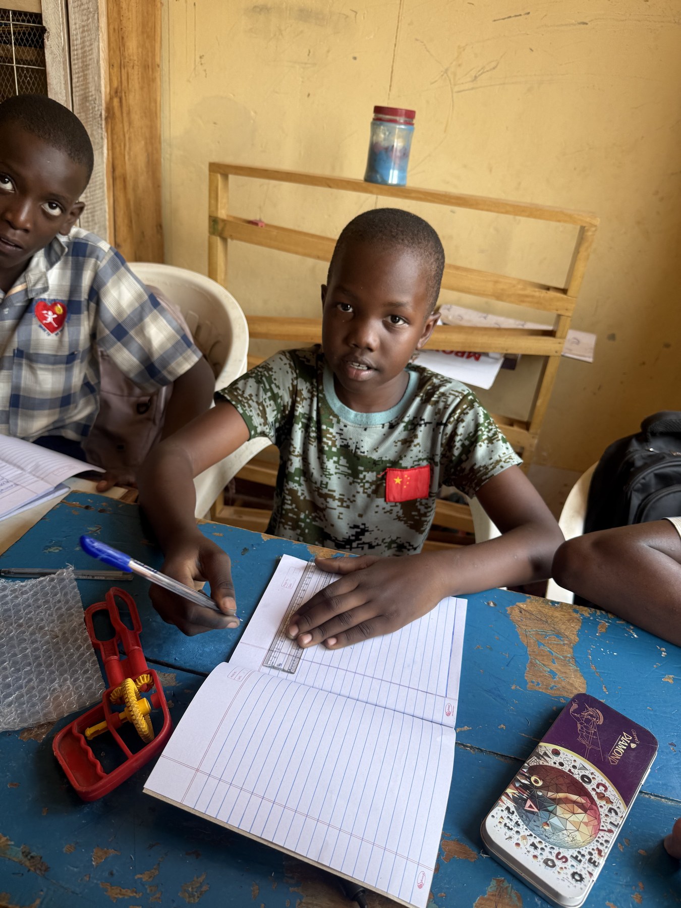 A student writing in his exercise book at CeSA