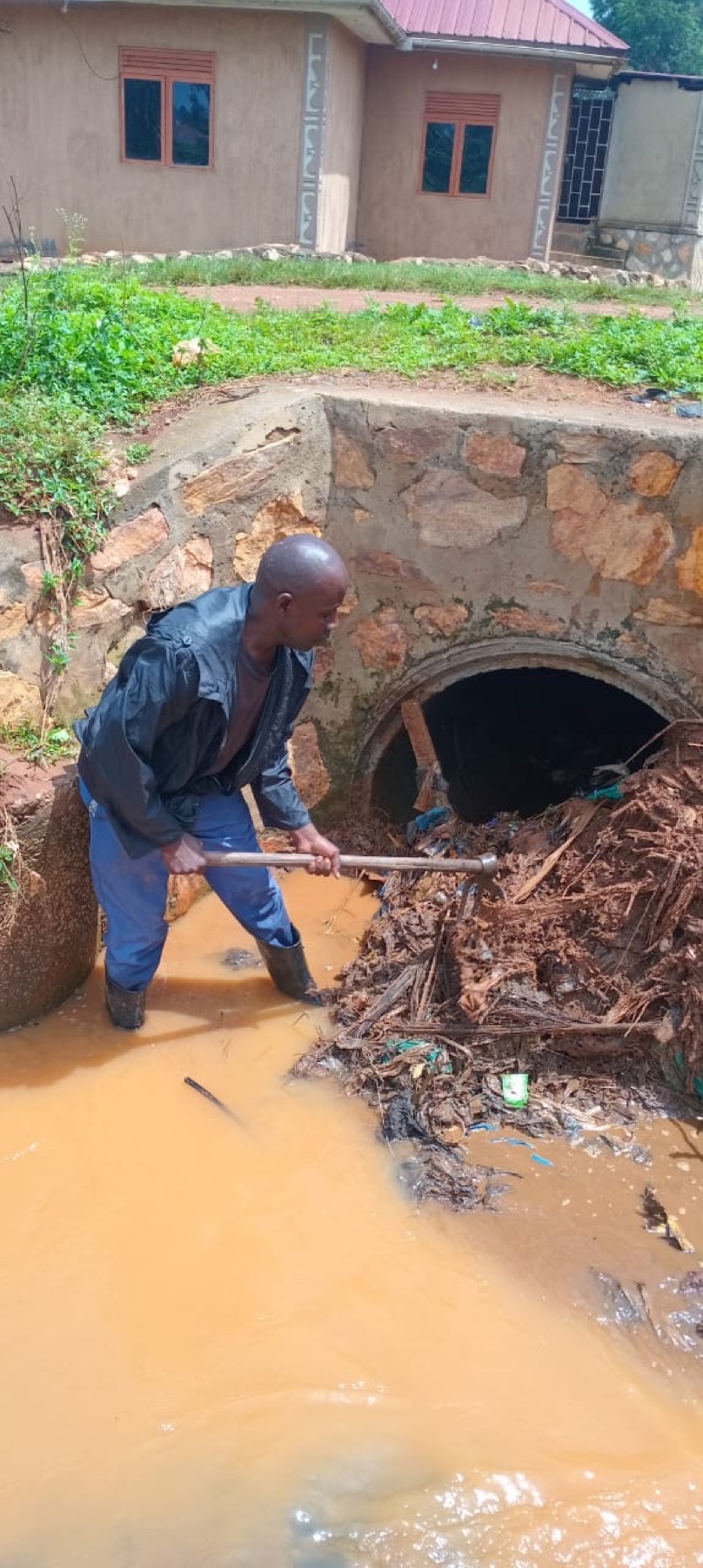 CeSA's Director clearing debris from the blocked culvert by hand